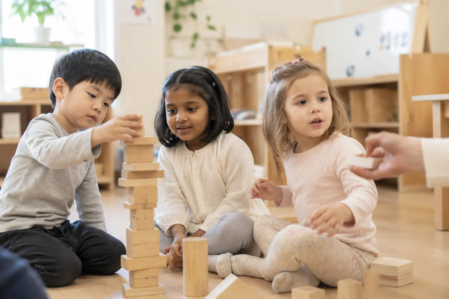 Children building with wooden blocks together