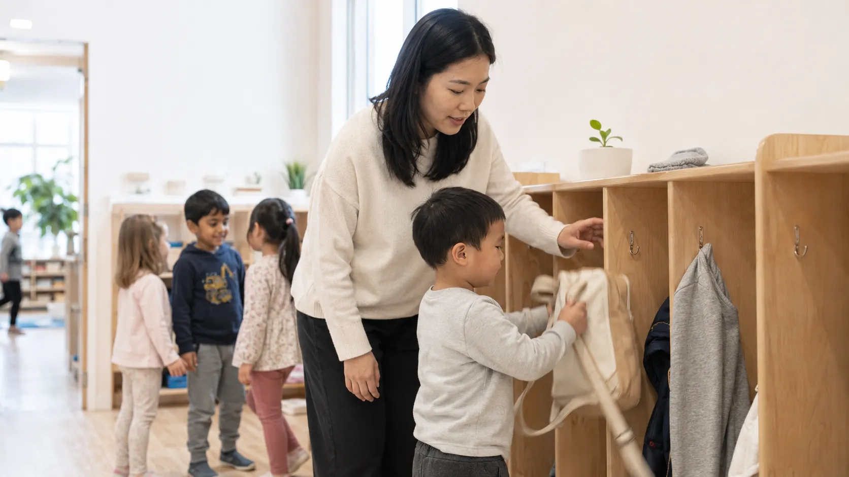 Educator helping a child organize belongings in a classroom cubby