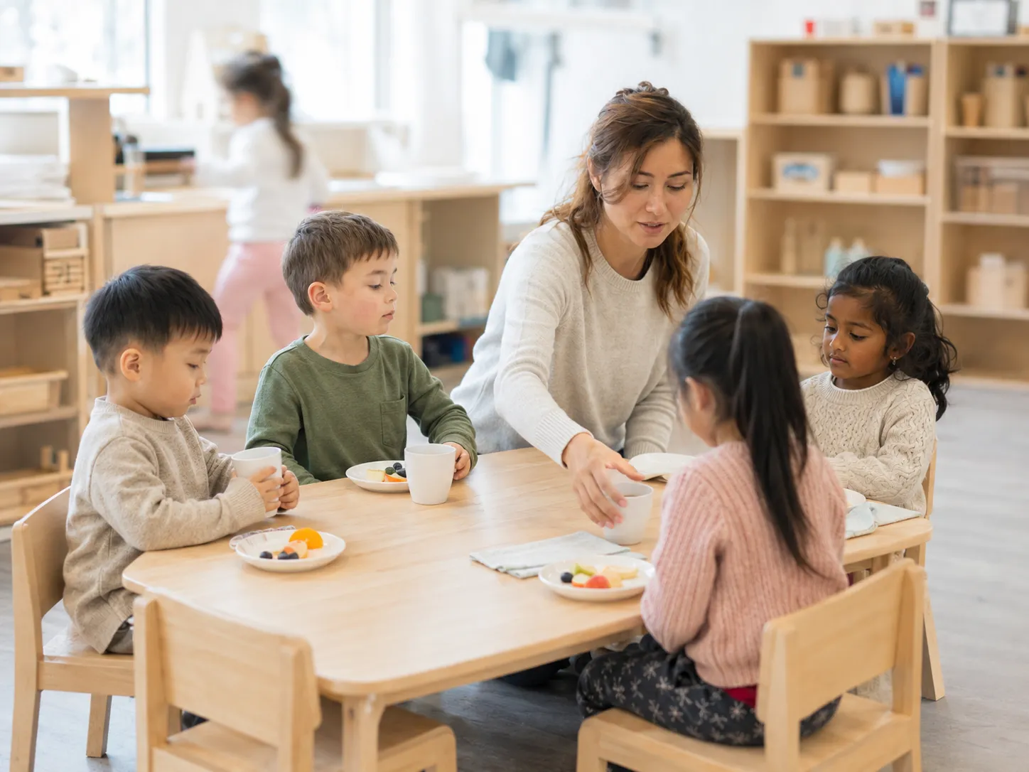 Educator supporting children during a snack and learning routine
