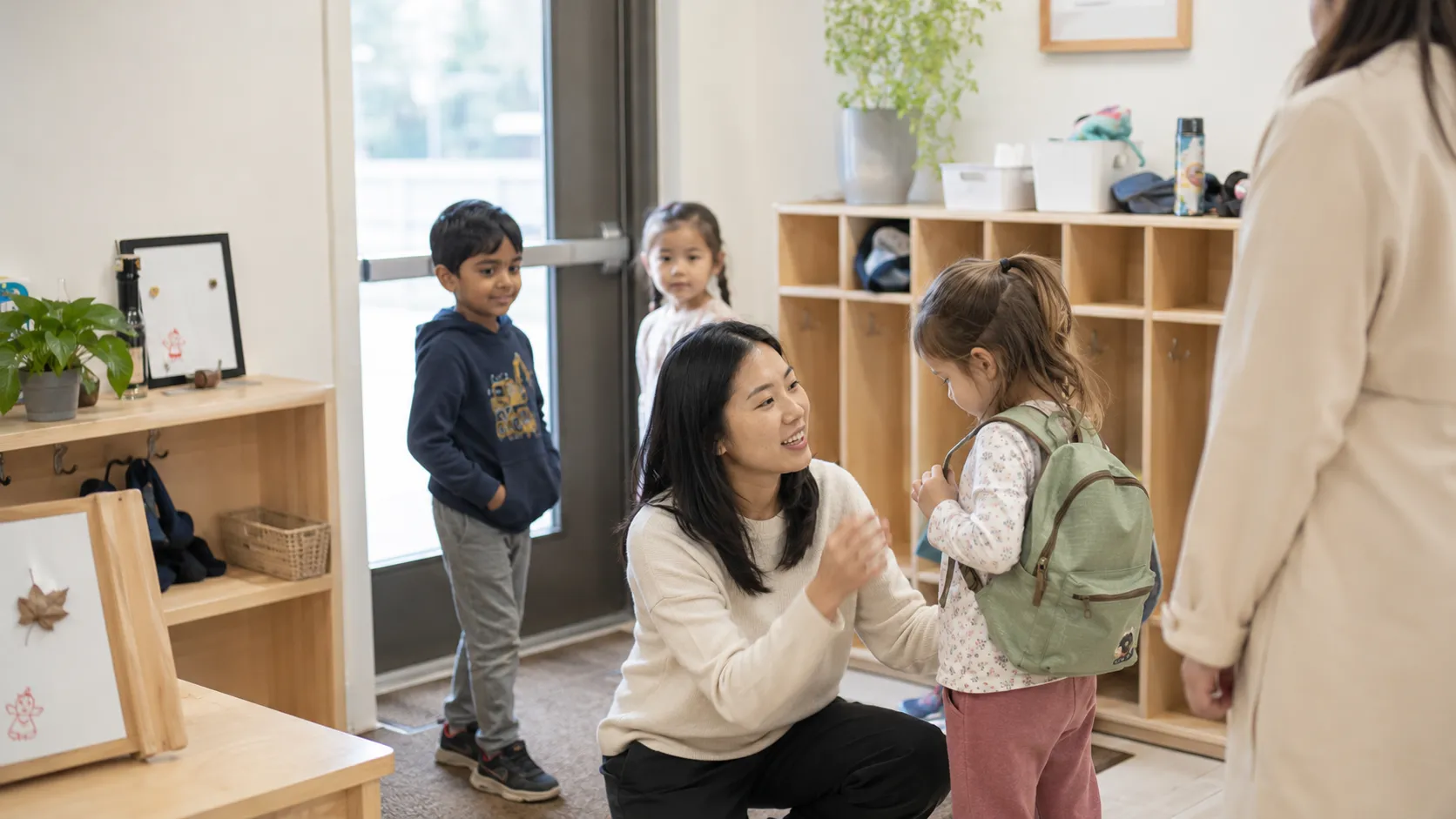 Educator greeting a child and parent at drop-off